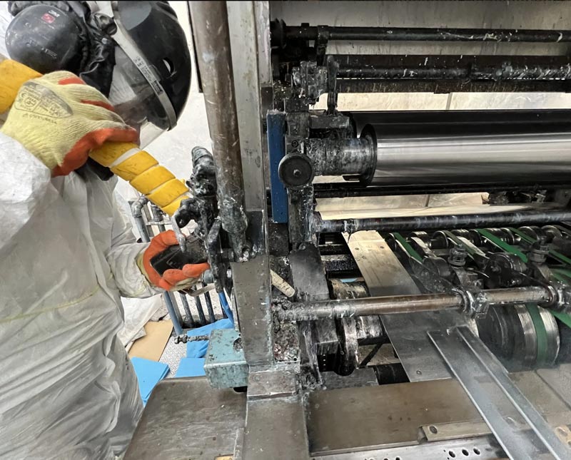 Technician performing dry ice cleaning on an industrial printer